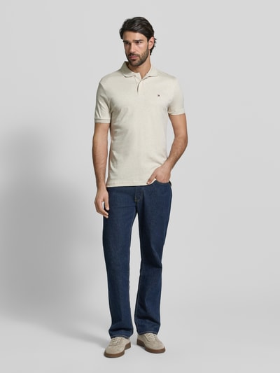 Männermodel trägt Regular Fit Poloshirt aus reiner Baumwolle Modell 'LIQUID COTTON' von Tommy Hilfiger, Melange-Optik, Ganzkörperansicht von vorne.