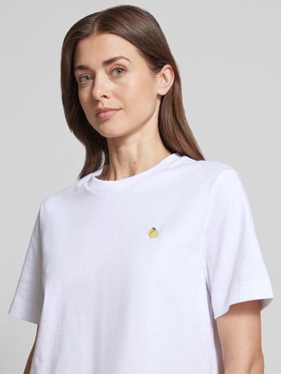 Modelka kobieca ma na sobie Boxy Fit T-Shirt aus reiner Baumwolle Modell 'ELLA' od Selected Femme, biała, jednolita struktura, krój boxy fit, okrągły dekolt, bawełna, zbliżenie na górną część ciała
