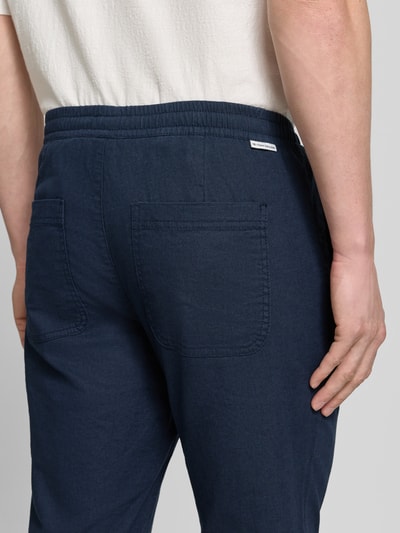 Männermodel trägt Gerade Hose aus Leinen-Baumwoll-Mix van Tom Tailor, look: effen, rechte pasvorm, labelpatch, steekzakken, achterzakken, mix van linnen en katoen, Ganzkörperansicht Rückansicht.