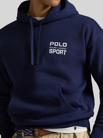 Mannermodel draagt 'Relaxed Fit Hoodie aus Baumwoll-Mix' van Polo Ralph Lauren in uni donkerblauw met labelprint, kangoeroezak, capuchon met trekkoord, lange mouwen met geribde boorden, sweatstof van katoenmix, Nahaufnahme bovenlichaam.