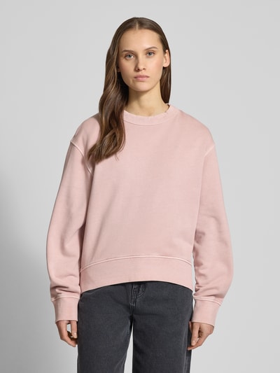 Vrouwenmodel draagt Relaxed Fit Sweatshirt mit Rundhalsausschnitt van G-Star Raw in lichtroze, katoen, verlengd achterpand, vooraanzicht bovenlichaam.