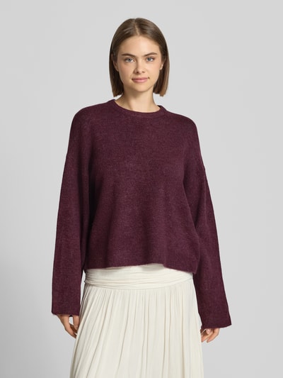 Frauenmodel trägt Relaxed Fit Pullover mit Rundhalsausschnitt Modell 'SIMONI' von ONLY in dunklem Violett, weiche Struktur, Nahaufnahme Oberkörper, Damen Pullover von ONLY.