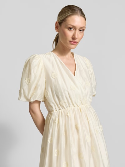 Frauenmodel trägt Minikleid mit V-Ausschnitt Modell 'CHAYA' von SUNCOO PARIS, Lyocell-Mix, Puffärmel, Wickel-Optik, Nahaufnahme Oberkörper.