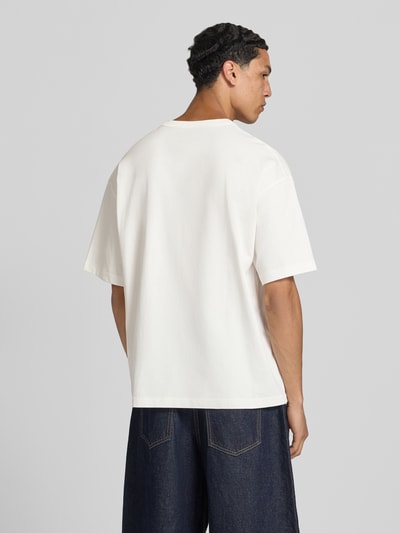 Męski model nosi t-shirt z nadrukiem z motywem model 'MENTON' od Jack & Jones, bawełna, krój relaxed fit, okrągły dekolt, długość tyłu w rozmiarze M: 71 cm, kolor biały, tekstura gładka, całkowity widok z tyłu.