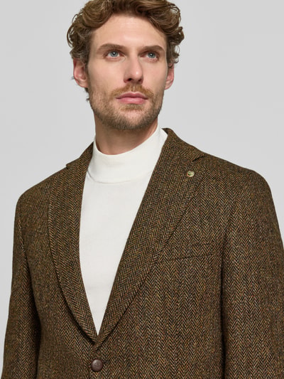 Męski model nosi marynarkę na 2 guziki z kieszeniami z patką Model 'Theo' od Carl Gross z czystej żywej wełny, krój slim fit, kołnierz z połami, kolor brązowy z deseniem, faktura widoczna, zbliżenie na górę ciała, kontekst: długość tyłu w rozmiarze 50: 75 cm, szerokość w rozmiarze 50: 44 cm, długość rękawów w rozmiarze 50: 66 cm