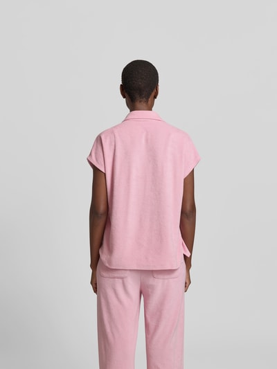 Frauenmodel trägt Poloshirt in Frottee-Optik von Juvia in Rosa, Baumwoll-Mix, Relaxed Fit, kurzärmelig, Ganzkörperansicht Rückansicht.
