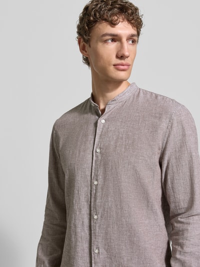 Męski model nosi Regular Fit Freizeithemd aus Leinen-Baumwoll-Mix od MCNEAL, beżowy, faktura lniano-bawełniana, stójka, zapięcie na guziki, długość tyłu w rozmiarze M 76 cm, szerokość w rozmiarze M 48 cm, długość rękawa 67 cm, zbliżenie na górną część ciała, widok z przodu.