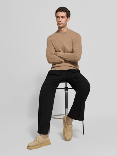 Männermodel trägt Stoffhose mit Bügelfalte Modell 'LEEK' von DRYKORN, schwarz, wide fit, Materialmix, Ganzkörperansicht von vorne