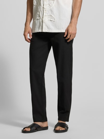 Männermodel trägt Hose aus Leinen-Baumwoll-Mix mit elastischem Bund von Lindbergh, schwarz, Regular-Fit, Eingrifftaschen, Nahaufnahme Unterkörper. Bundweite Größe M: 40 cm, Innenbeinlänge: 79 cm.