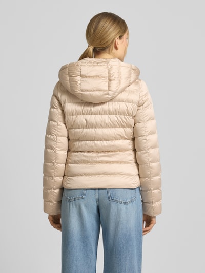 Frauenmodel trägt taillierte Steppjacke mit Kapuze und Zweiwege-Reißverschluss Modell 'ANYA' von Beaumont Amsterdam, beige, Ganzkörperansicht Rückansicht.