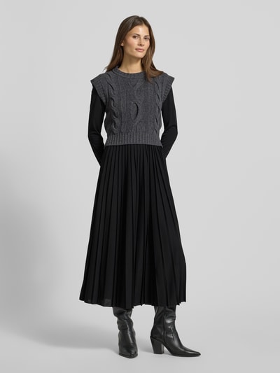 Vrouwenmodel draagt Maxi-Freizeitkleid im Set mit Strick-Pullunder aus reiner Schurwolle Modell 'EBRO' van Weekend Max Mara; zwart, uni, plissé en gebreide texturen, losse pasvorm, maxi-lengte, ronde hals, lange mouwen, vooraanzicht hele lichaam.