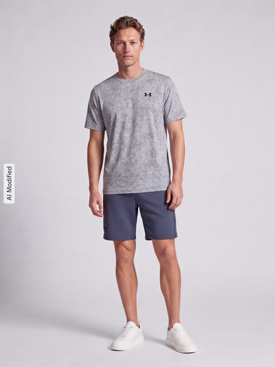 Männermodel trägt Regular Fit T-Shirt mit Strukturmuster Modell 'Pixelate' von Under Armour, graue Töne, glatte Textur, Ganzkörperansicht von vorne, Herren Sport-T-Shirt von Under Armour, KI-modifiziertes Bild.