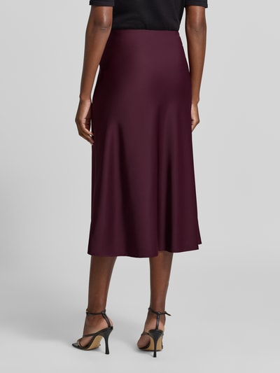 Frauenmodel trägt Midirock mit elastischem Bund Modell 'PELLA' von YAS, bordeauxfarben, Satin, A-Linie, Ganzkörperansicht Rückansicht.