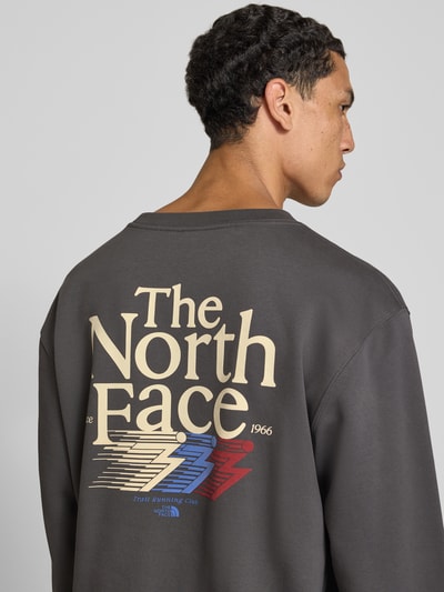 Männermodel trägt Relaxed Fit Sweatshirt aus katoenmix von The North Face met logoprint, heren sweatshirt, ruglengte maat M 68 cm, mouwlengte maat M 68 cm, ronde hals, elastische boordjes, Ganzkörperansicht Rückansicht