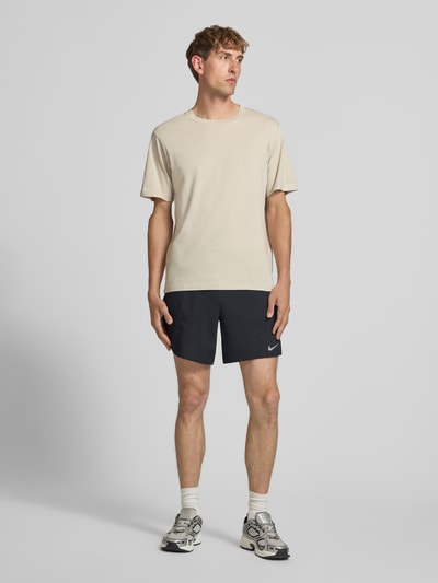 Männermodel trägt schwarze Regular Fit Sportshorts mit Dri-FIT-Technologie Modell 'STRIDE' von Nike, Herren Sportshorts, Ganzkörperansicht von vorne.