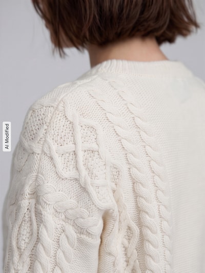 Vrouwenmodel draagt Regular fit pullover uit pure scheerwol model 'ALBEN' van Weekend Max Mara in crème met kabelstructuur, detailopname, KI-modificeerd beeld.