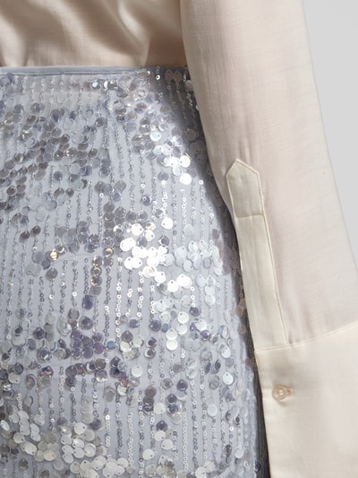 Frauenmodel trägt Midirock mit Paillettenbesatz Modell 'SARCA' von Marella in hellem Silber, gerader Schnitt, Nahaufnahme Oberkörper.