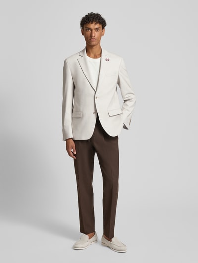 Männermodel trägt Slim Fit 2-Knopf-Sakko mit Pattentaschen von ATELIER TORINO in Beige, Material-Mix, Reverskragen, Ganzkörperansicht von vorne.