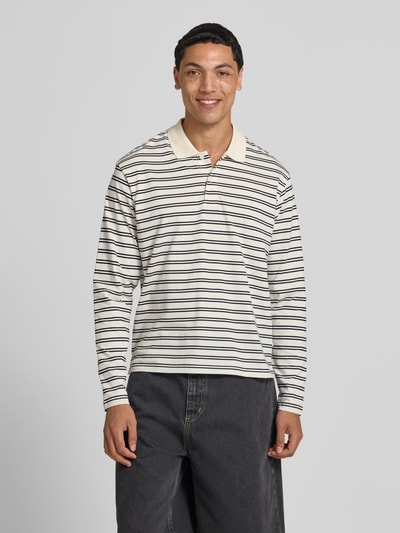 Mannenmodel draagt regular fit poloshirt met streepmotief model 'CASSIS' van Jack & Jones, puur katoen, shirt met lange mouwen, knoopsluiting, ruglengte bij maat M 66 cm, voorkant hele lichaam
