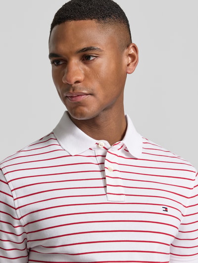 Männermodel trägt Regular Fit Poloshirt aus Baumwoll-Mix von Tommy Hilfiger, Optik: Allover-Muster, Nahaufnahme Oberkörper.