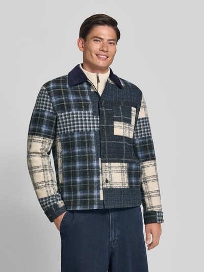 Männermodel trägt Regular Fit Hemdjacke mit Eingrifftaschen von MCNEAL in blau-beige kariertem Muster, Nahaufnahme Oberkörper. Herren Hemdjacke mit Umlegekragen, durchgehender Knopfleiste und umgeschlagenen Ärmelabschlüssen, Rückenlänge bei Größe M 73 cm.