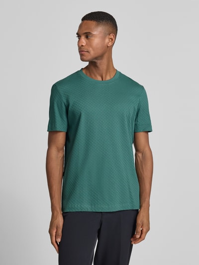 Męski model nosi T-Shirt z prążkowanym okrągłym dekoltem od JOOP! Collection, bawełna, regular fit, zielony kolor. Całość z przodu.