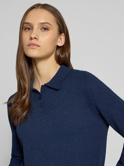 Frauenmodel trägt Langärmliger Polo-Strickpullover aus Bouclé-Garn von Review in dunklem Blau, Strick-Optik, lockere Passform, Nahaufnahme Oberkörper.