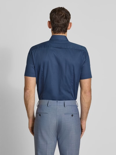 Männermodel trägt Slim Fit Business-Hemd aus Baumwolle mit Kentkragen von Jake*s, glatter Stoff, dunkles Blau, Ganzkörperansicht Rückansicht.