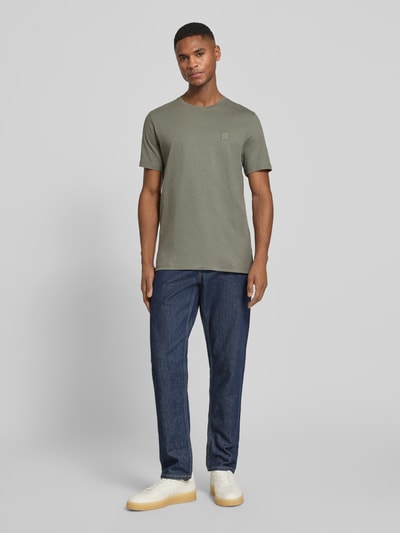 Männermodel trägt Regular Fit T-Shirt aus reiner Baumwolle Modell 'TALES' von BOSS Orange in Uni-Optik, Ganzkörperansicht von vorne.