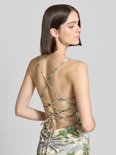 Vrouwenmodel draagt Abendkleid mit rückseitiger Schnürung van Mascara in satijn met bloemenprint, aansluitende fit, rugzijde gekruiste spaghettibandjes en draperingen, rugveter, detailopname rugzijde.