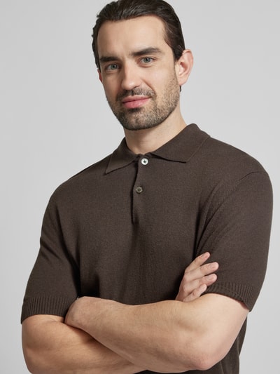 Männermodel trägt Slim Fit Poloshirt mit kasjmier-aandeel van FTC Cashmere in bruin met polokraag en knoopsluiting, katoenmix, 1/2-mouwen, ruglengte maat 50: 68 cm, nahaufnahme bovenlichaam.