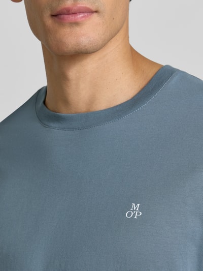 Männermodel trägt Shaped Fit Langarmshirt aus reiner Baumwolle von Marc O'Polo in Blau mit kleinem Logo, Nahaufnahme Oberkörper. Herren Langarmshirt von Marc O'Polo