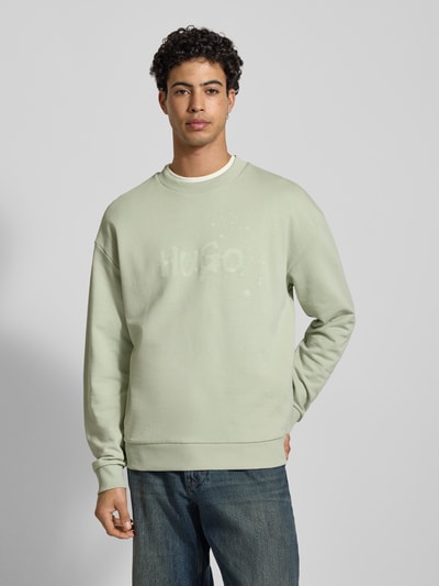 Männermodel trägt Regular Fit Sweatshirt aus reiner Baumwolle Modell 'NIEROFIX_CREW' von Hugo Blue, unifarben, Label-Print, Ganzkörperansicht von vorne.