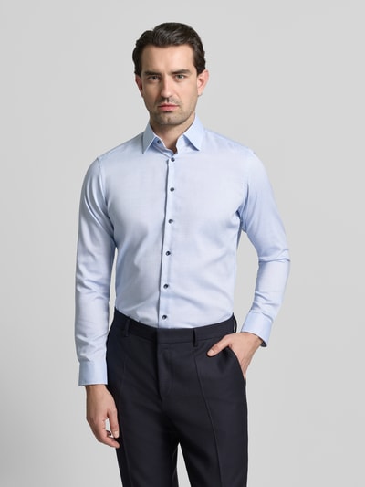 Männermodel trägt Regular Fit Business Hemd aus Baumwolle mit Kentkragen von Christian Berg Men, hellblau, Knopfleiste, Ganzkörperansicht von vorne.