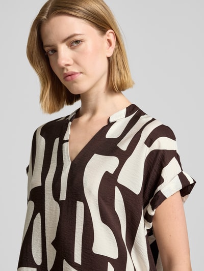 Frauenmodel trägt knielanges Kleid mit Tunikakragen Modell 'Wulana dune' von OPUS aus Viskose-Mix, Loose-Fit, grafisches Muster, Nahaufnahme Oberkörper.