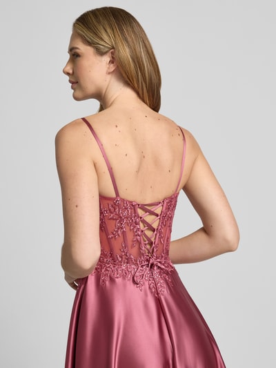 Frauenmodel trägt Corsagenkleid mit Stitchings und Ziersteinbesatz von Luxuar aus rosafarbenem Satin, taillierter Maxikleid-Schnitt, dekorative rückseitige Schnürung; Detailaufnahme Rückenansicht.