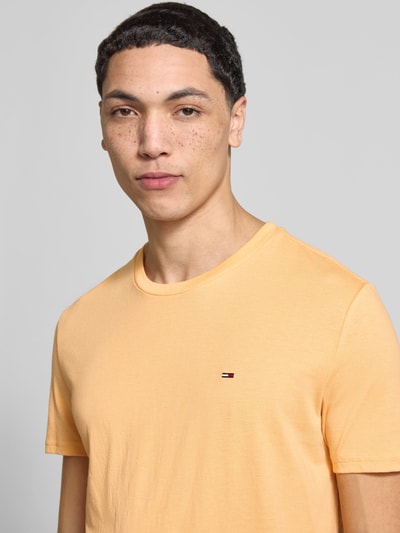 Männermodel draagt Slim Fit T-shirt uit katoenmix model 'JASPE HERITAGE' van Tommy Jeans in gemêleerde look, logostitching, korte mouw, heren, mix van katoen, Nahaufnahme Oberkörper.