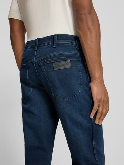 Männermodel trägt Straight Fit Jeans im 5-Pocket-Design Modell 'Texas' von Wrangler aus Baumwoll-Mix mit Stretch-Anteil, Gerader-Schnitt, Label-Detail, dunkles Blau, Nahaufnahme Rückansicht.