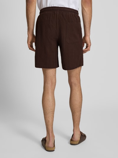 Männermodel trägt Loose Fit Shorts aus reiner Baumwolle Modell 'CRUZ' von Only & Sons, Optik: Unifarben, Materialverarbeitung: Seersucker, mit Bundabschluss elastisch, Tunnelzug und Taschen, Ganzkörperansicht Rückansicht.