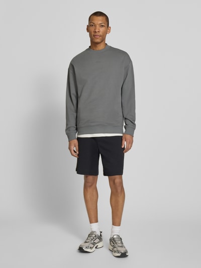 Männermodel trägt Regular Fit Sweatshirt aus reiner Baumwolle Modell 'DAPOCREW' von HUGO, unifarben, Rundhals, Ganzkörperansicht von vorne.