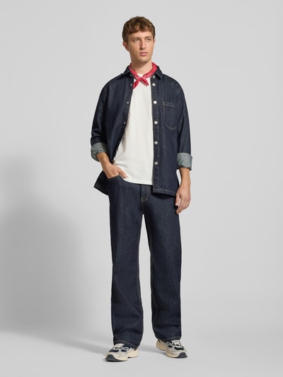 Mannelijk model draagt Baggy Fit Jeans mit Eingrifftaschen van REVIEW in donkerblauw, puur katoen, Steekzakken, knoop- en ritssluiting, bandwijdte maat 32: 42 cm, binnenbeenlengte maat 32: 80 cm, jeanslook. Ganzkörperansicht von voren.