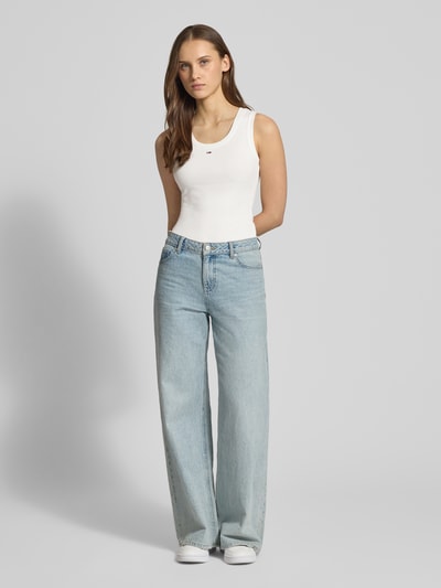 Vrouwenmodel draagt 'Slim Fit Tank Top uit katoenmix' van Tommy Jeans in effen kleuren met logodetail, U-hals, brede bandjes, fijnrib, slim fit, frontaal volledige lichaamsweergave.