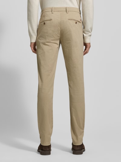 Männermodel trägt Slim Fit Chino aus Baumwoll-Mix Modell 'BLEECKER' von Tommy Hilfiger in Beige, unifarben, Ganzkörperansicht Rückansicht.