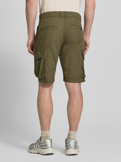 Männermodel trägt Bermudas mit Cargotaschen van camel active in olijfgroen, pure katoen, regular fit, cargozakken, labeldetail, ganzkörperansicht rückansicht.