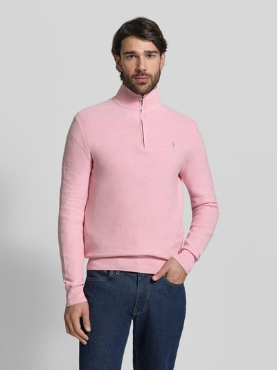 Männermodel trägt Regular Fit Troyer aus reiner Baumwolle von Polo Ralph Lauren in Hellrosa, Optik: Unifarben, Logo-Detail, Piqué-Struktur, Langarm, Kragenform: Troyer, Verschluss: kurzer Reißverschluss, Ärmelabschluss und Rumpfabschluss gerippt, Materialverarbeitung: Piqué, Ganzkörperansicht von vorne.