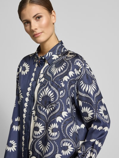 Modelka kobieca nosi Oversized Langarmbluse aus reinen Seide Modell 'LASTRA' od Weekend Max Mara, wzór kwiatowy, odcienie niebieskiego i bieli, czysta jedwabna tkanina, widok na górną część ciała z przodu.