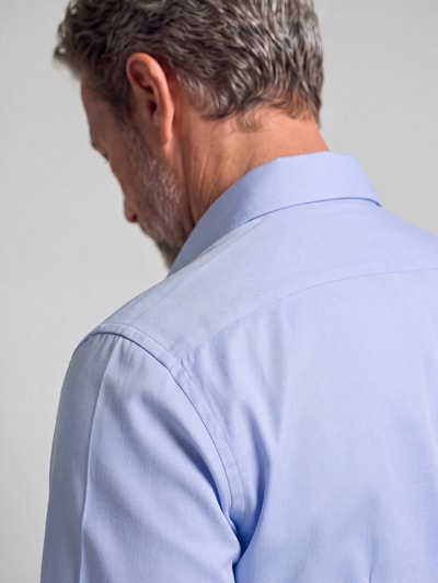 Männermodel trägt Slim Fit Business Hemd mit Kentkragen aus Feintwill von Seidensticker in Hellblau, feine Webstruktur, Detailaufnahme Rückansicht.
