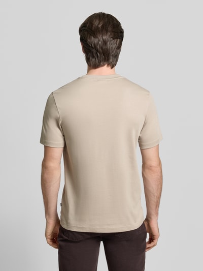 Männermodel trägt T-Shirt mit Label-Stitching Modell 'Priamo' von JOOP! Collection in Beige, reine Baumwolle, Rückansicht, Ganzkörperansicht.