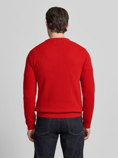 Männermodel trägt Oversized Strickpullover mit gerippten Abschlüssen von Casual Friday, Mieszanka wełny lana, okrągły dekolt, długość tyłu 68 cm, długość rękawów 70 cm, krój oversized, prążkowane wykończenia, intensywny czerwony kolor, Ganzkörperansicht Rückansicht