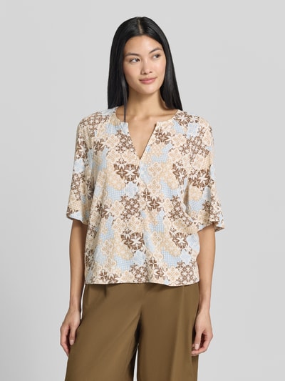 Frauenmodel trägt Relaxed Fit Kurzarmbluse aus Viskose-Mix von s.Oliver RED LABEL, gemustert in Beige, Blau und Braun, Nahaufnahme Oberkörper.